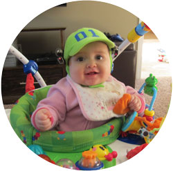 a baby looks at the camera while wearing a hat with looxcie cameras attached during one of their Seedlings home recording sessions