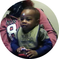 a baby participates in an eye tracking study. He wears a target sticker on his forehead and looks at a computer screen.